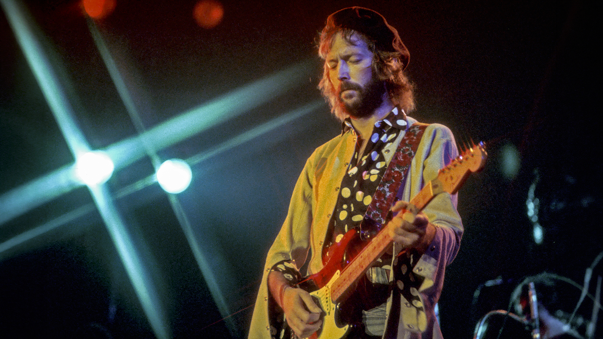 Eric Clapton performs onstage with his Fender Stratocaster electric guitar in circa 1977.