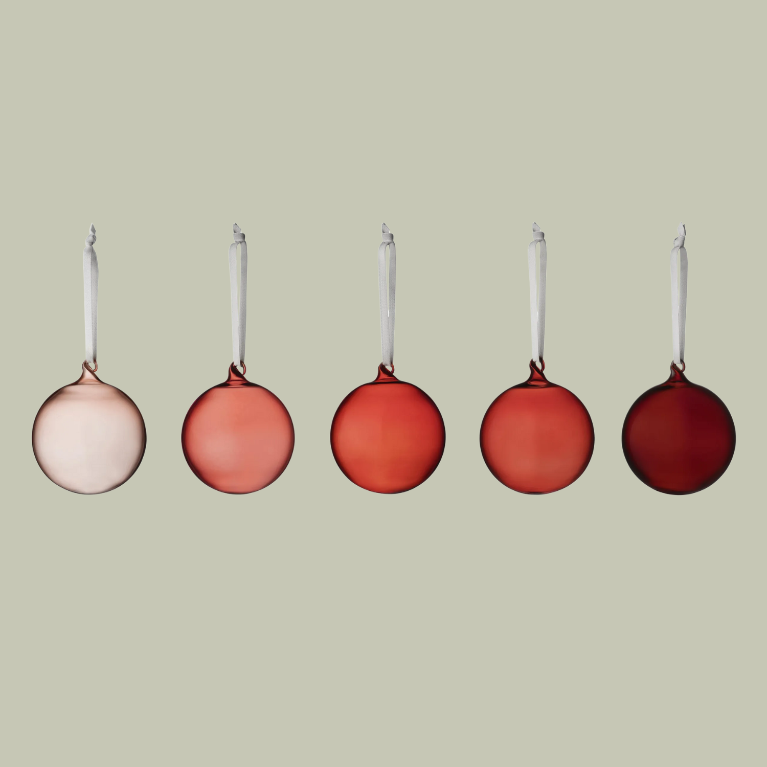 A set of five glass baubles in shades of red