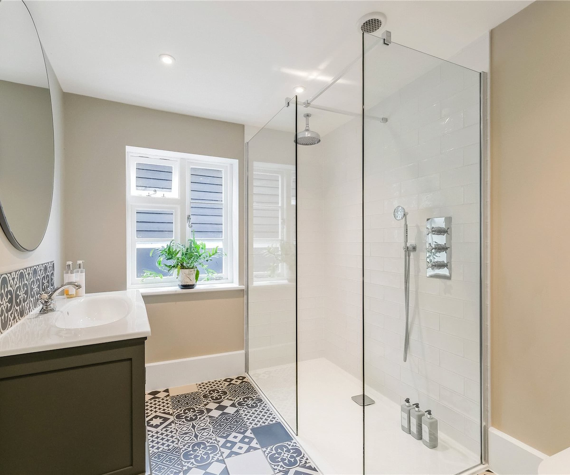 A small bathroom with a walk in shower made with white tiles