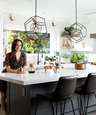 White kitchen designed by Hayley Orrantia, The Goldbergs actress, crystal lights over kitchen island