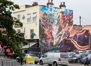 Car park mural of a motorbike driving into a stunning scenic ravine