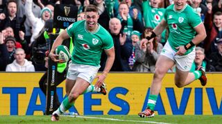 Jack Crowley (L) runs over the line to score a try for Ireland at the Six Nations 2024