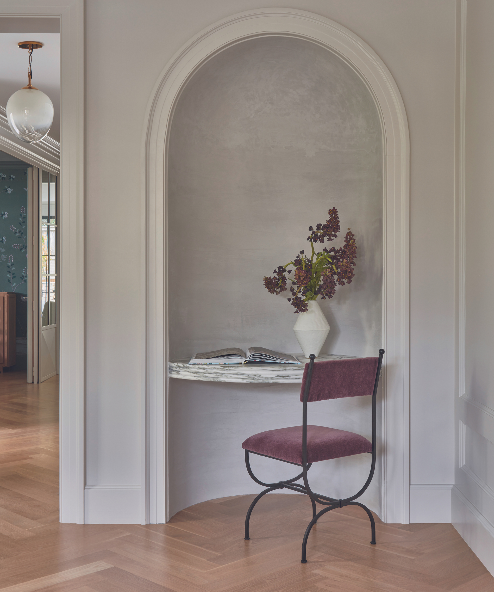 concave area with office desk and chair in hallway with vase of flowers