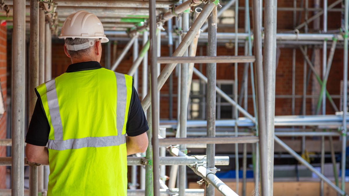 a builder in front of some scaffolding