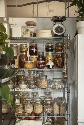 wire storage rack with various glass jars filled with food by ikea