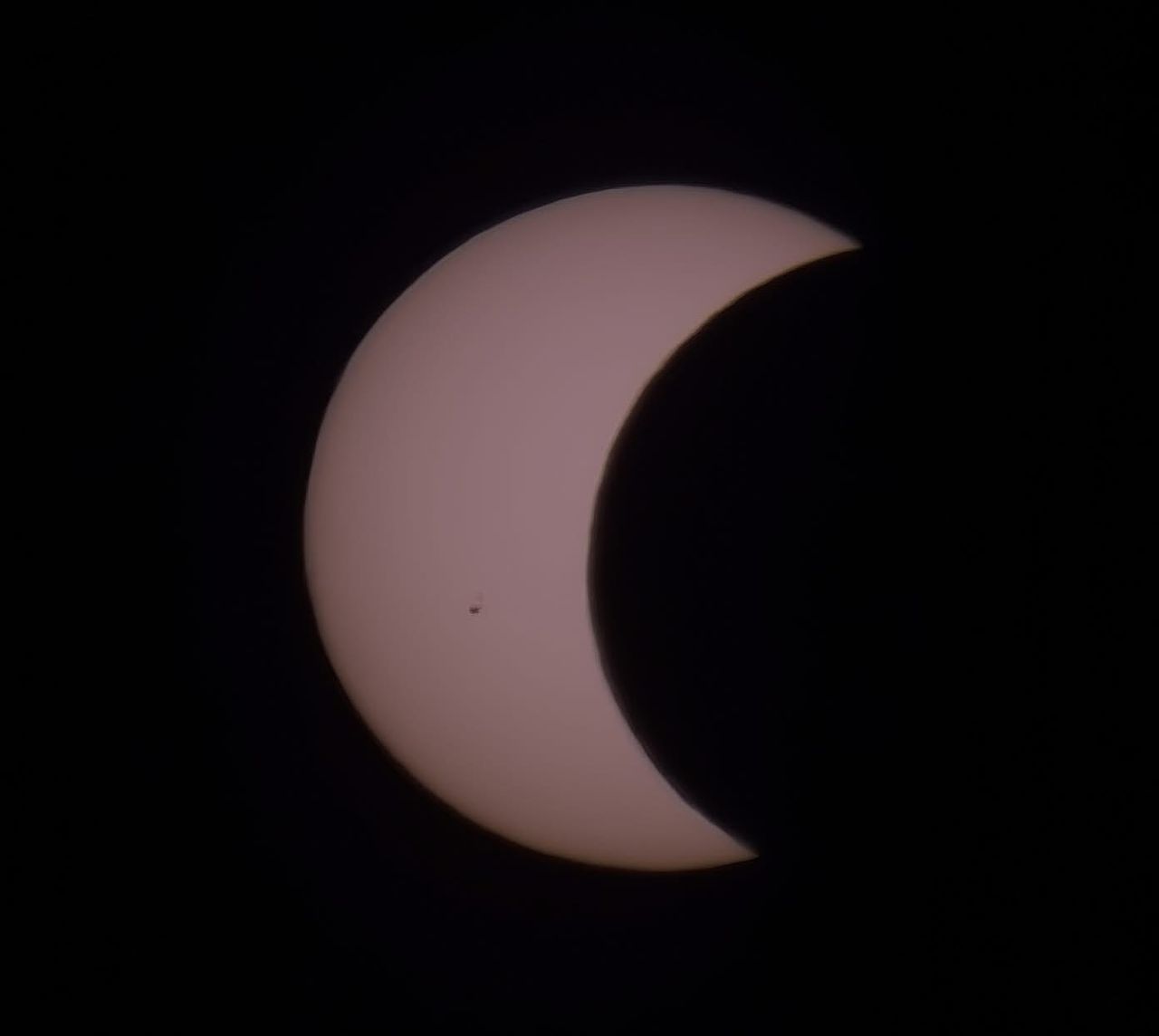 close up view of the sun appearing as a crescent as the moon starts to cover it.