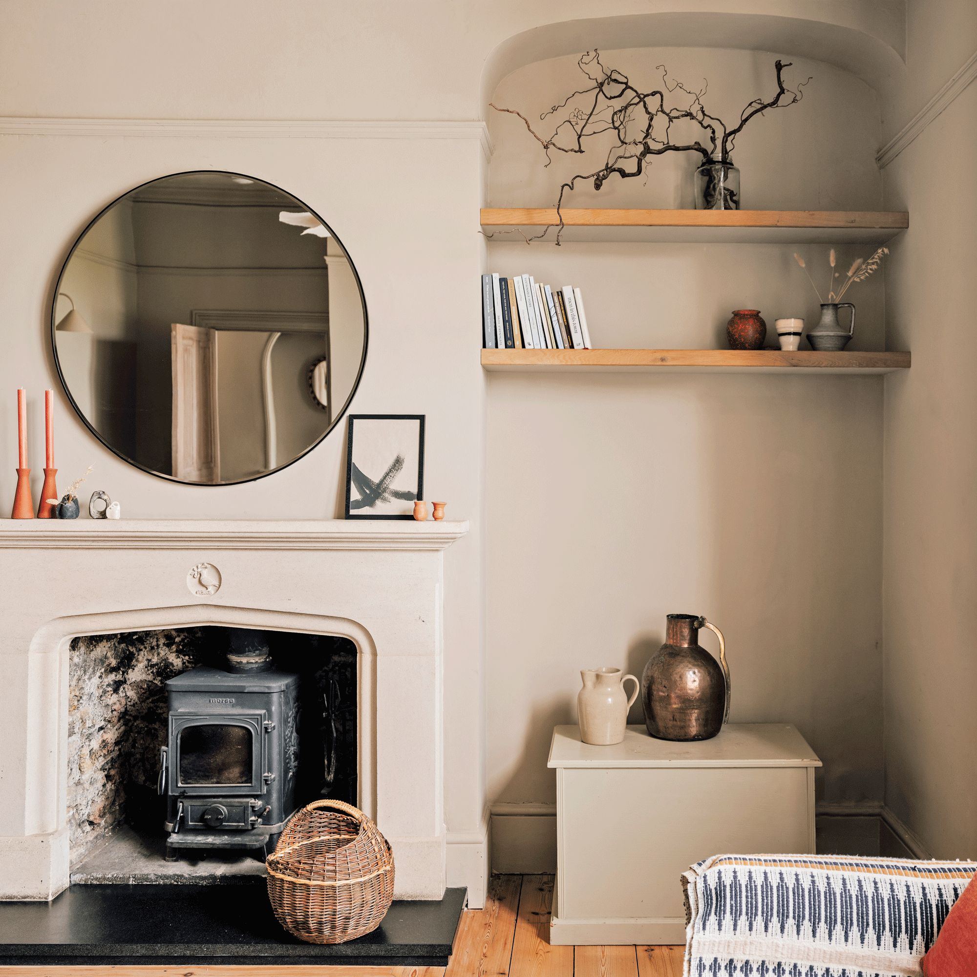 a neutral living room with an arched alcove with shelving and a traditional frreplace