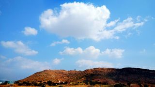 A hill in Kurnool district, Andhra Pradesh in India with white clouds and blue sky