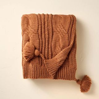 An orange throw blanket from Magnolia with tufts