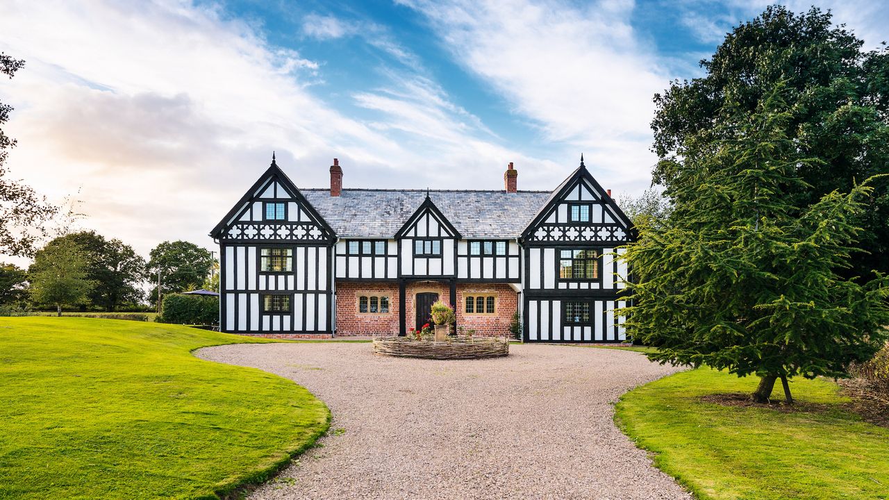 large tudor house style with gravel driveway