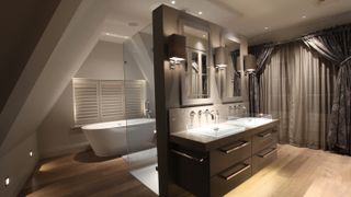 large bathroom with dividing wall and twin basins with mood lighting