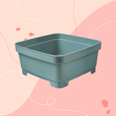 Aldi olive green washing up bowl on a pink background.