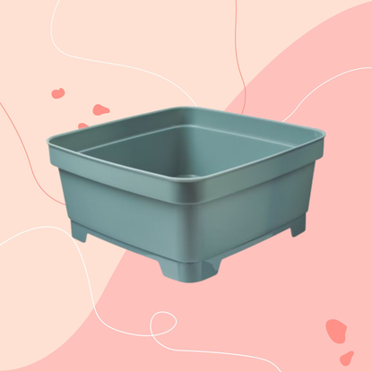 Aldi olive green washing up bowl on a pink background.