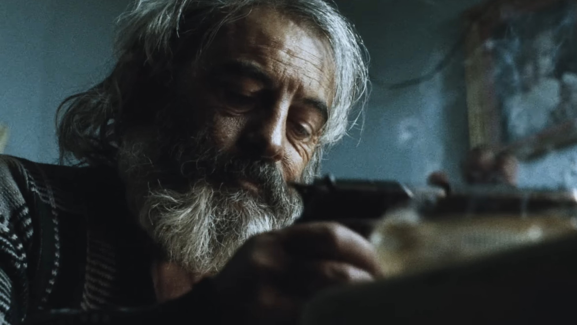 Emilio Echevarria looking at his gun in Amores Perros.