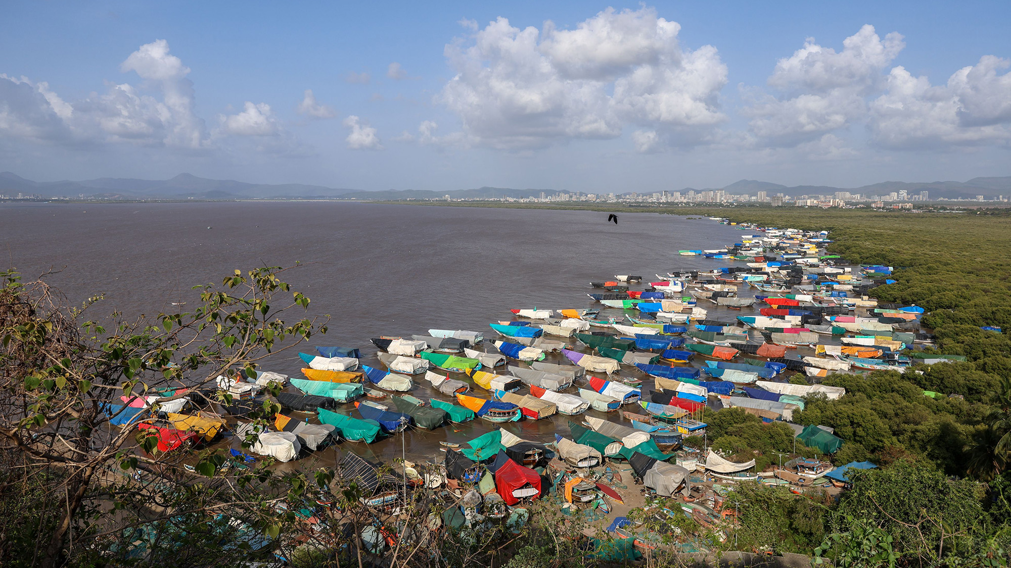 Anchored fishing boats are covered with tarpaulins as the fishing season ends near the Arabian Sea shore at the Chowk Dongri village, on the outskirts of Mumbai, India