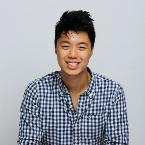 Image of a man in a blue and white check shirt in front of a light gray background.