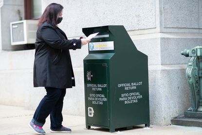 Voter drops off her ballot in Phliadelphia