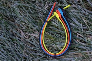 four hiplok Z loks in their bright primary colours laid on a frozen grassy ground