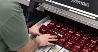 Derek Smith of Keeley Electronics loads Keeley pedals into a Mimaki UV printer as a new batch of Andy Timmons signature Halo delay pedal is made.