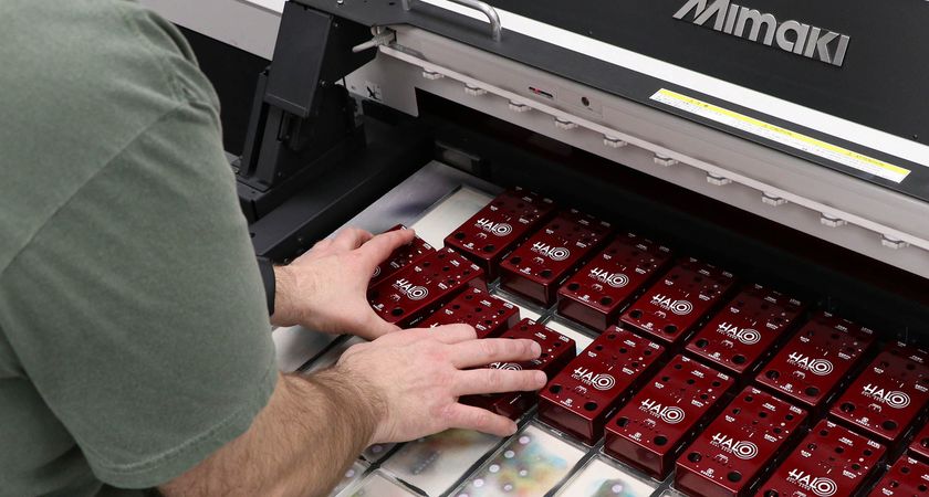 Derek Smith of Keeley Electronics loads Keeley pedals into a Mimaki UV printer as a new batch of Andy Timmons signature Halo delay pedal is made.