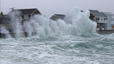 Scituate, MA - February 13: Waves crash against homes during a noreaster. 