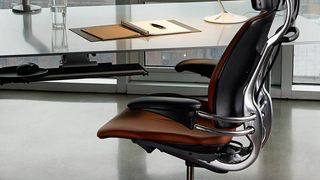 Humanscale Freedom office chair parked at a glass desk in an office