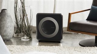 Black air purifier in the middle of a living room space
