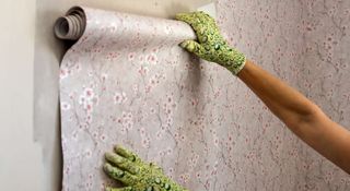Woman aligning patterned wallpaper