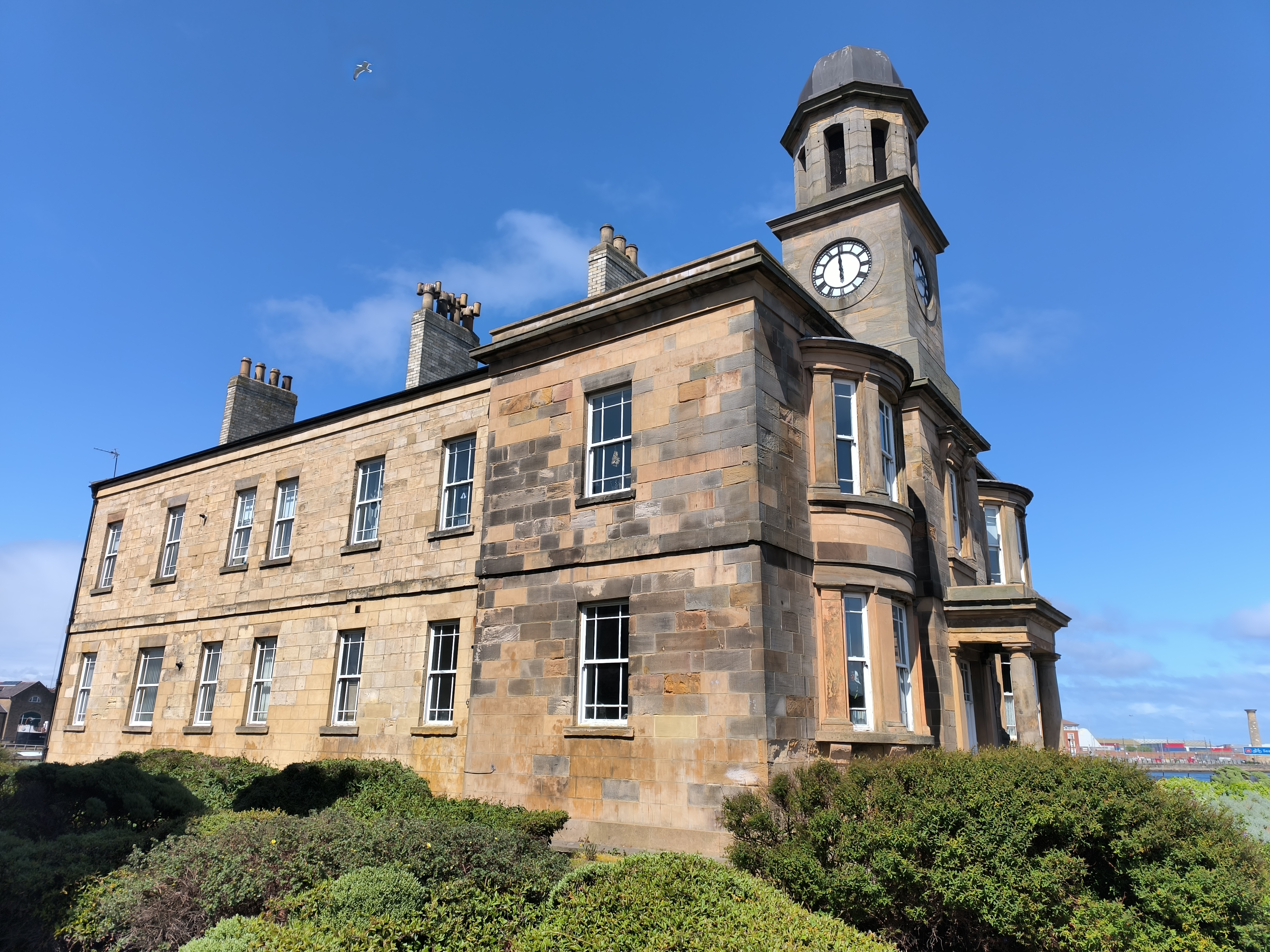 A historic stone building with a clock tower on one corner.