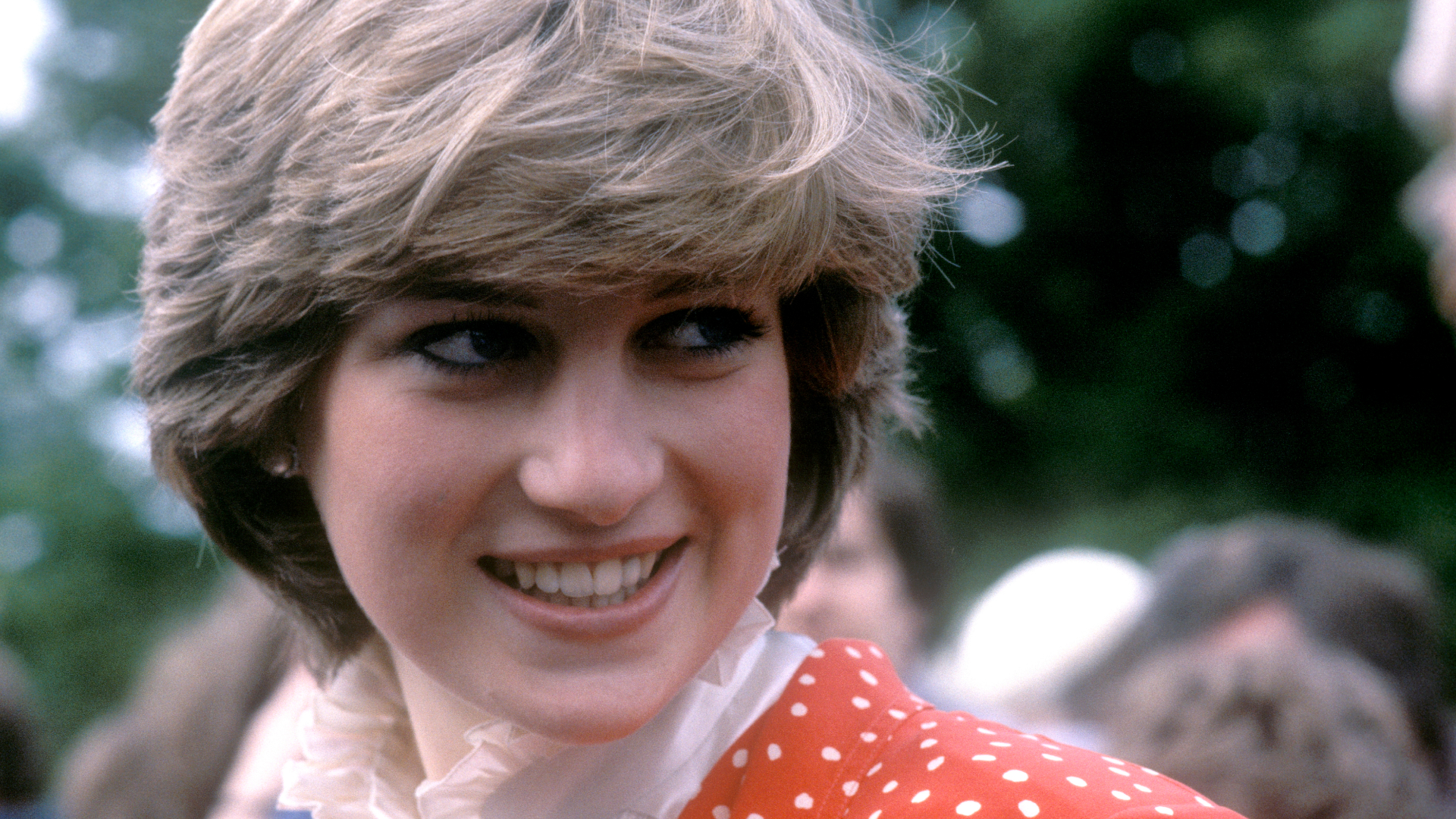 Princess Diana wearing a red polka dot dress smiling in 1981