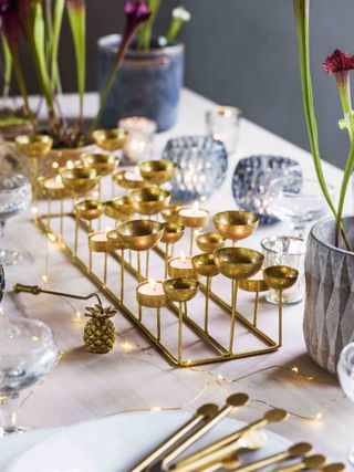 Christmas gold tealight holder centerpiece on table with festive ornaments
