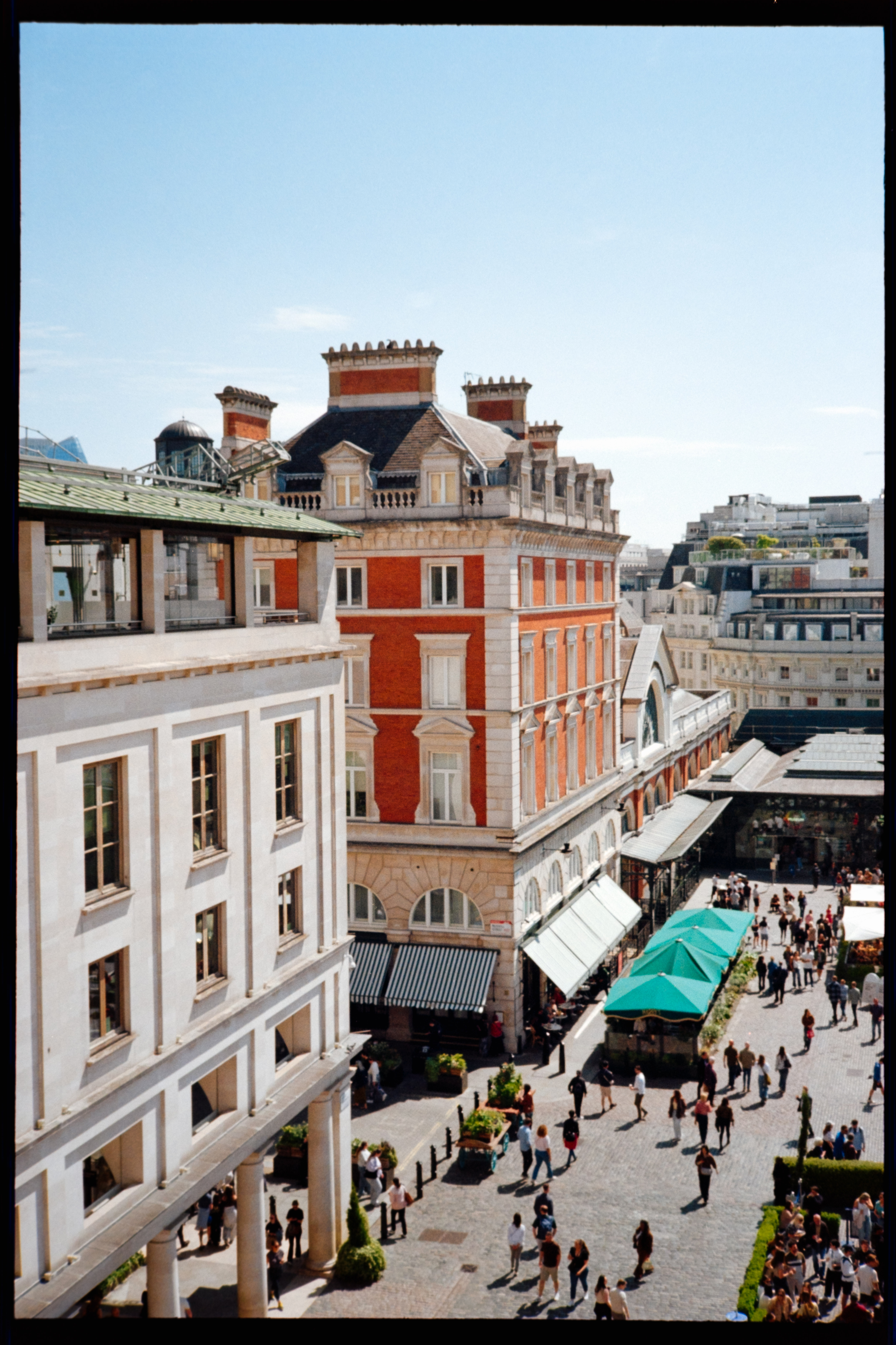 A high-angle view of Covent Garden with historic buildings and people walking through the square.