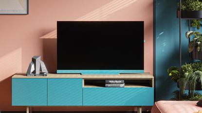 Loewe We.SEE TV with blue soundbar on a blue TV bench