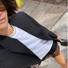 Woman in black blazer, white t-shirt and black lace skirt