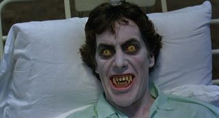 A gruesome man with yellow eyes and fangs in 'An American Werewolf in London'