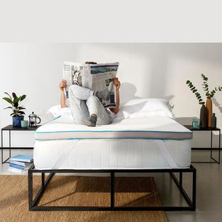 Simba mattress topper on a bed with a person laid on it reading a newspaper