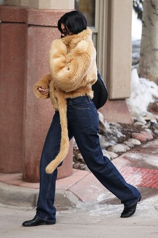 Kylie Jenner wearing a fur jacket and jeans in Aspen.