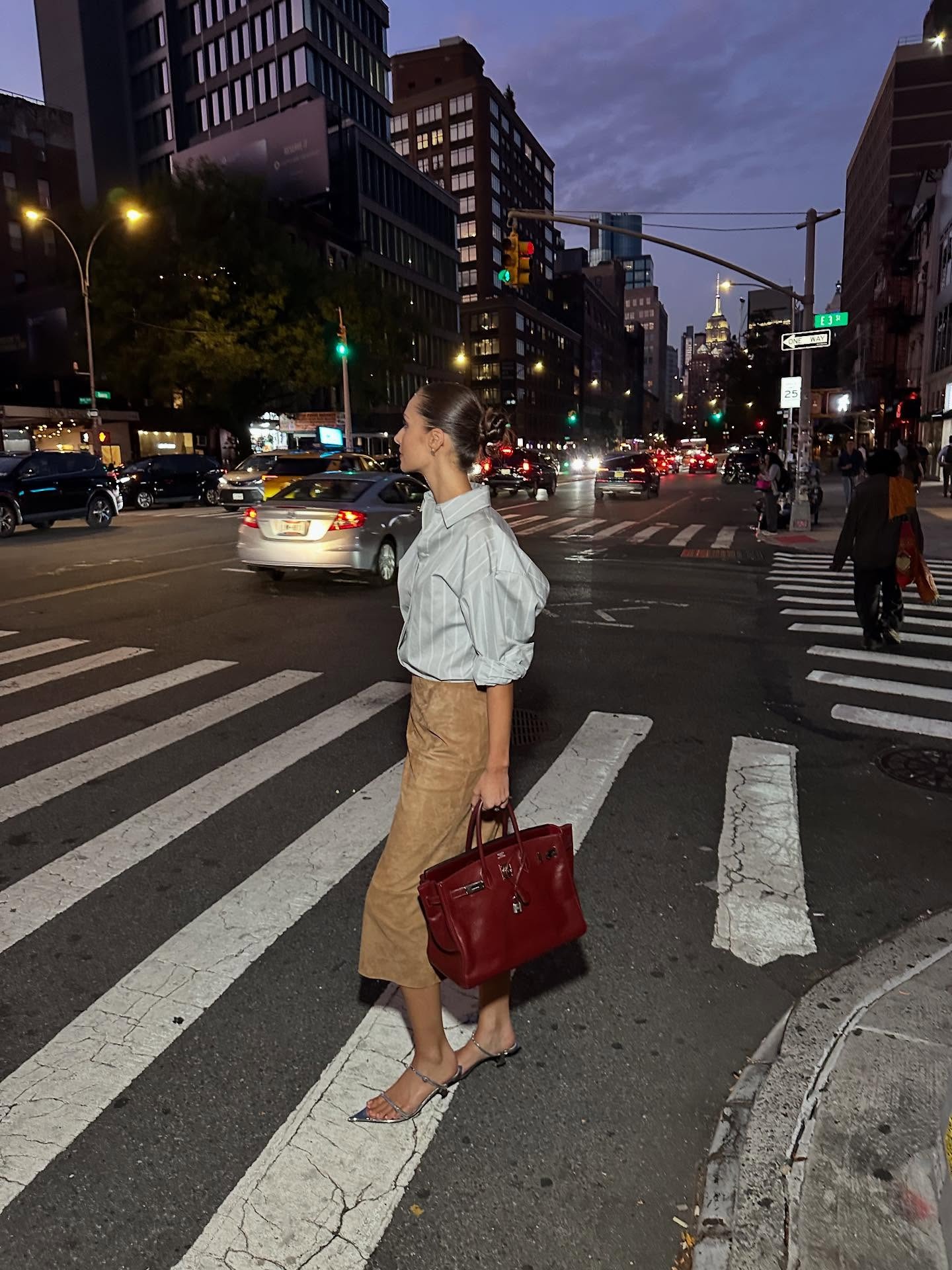 @piamance wearing a button-down shirt with a suede pencil skirt and burgundy bag.