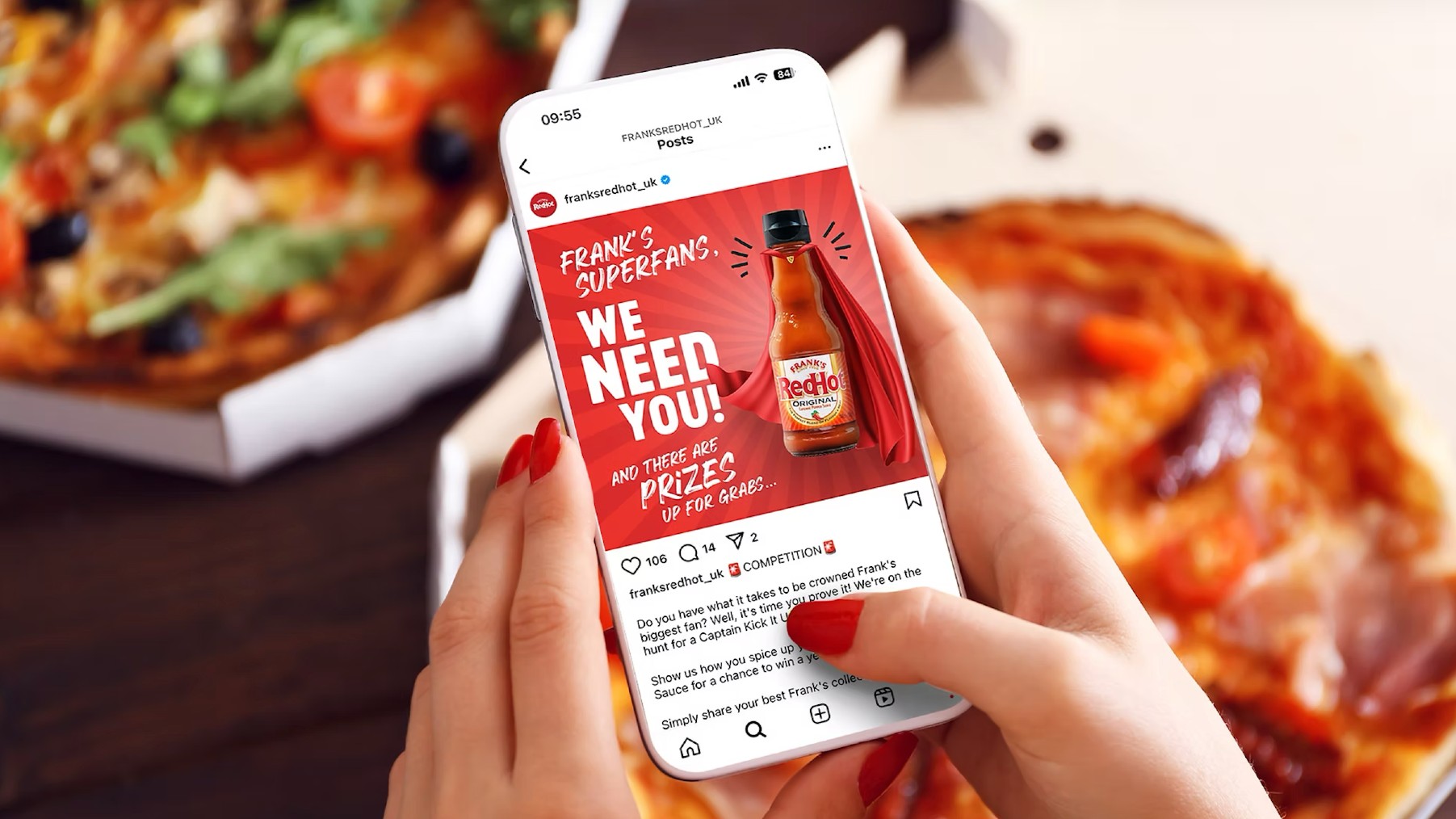 A person holds a smartphone displaying a social media contest page for Frank's RedHot sauce, set against a background of fresh pizzas.
