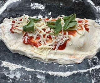 Uncooked calzone on a kitchen counter.