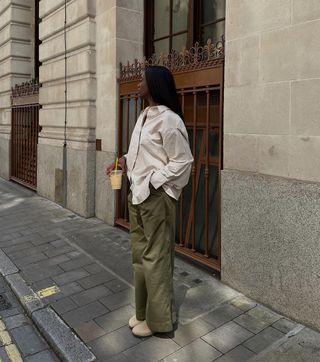 @_livmadeline wearing a linen shirt, wide-leg trousers and clogs