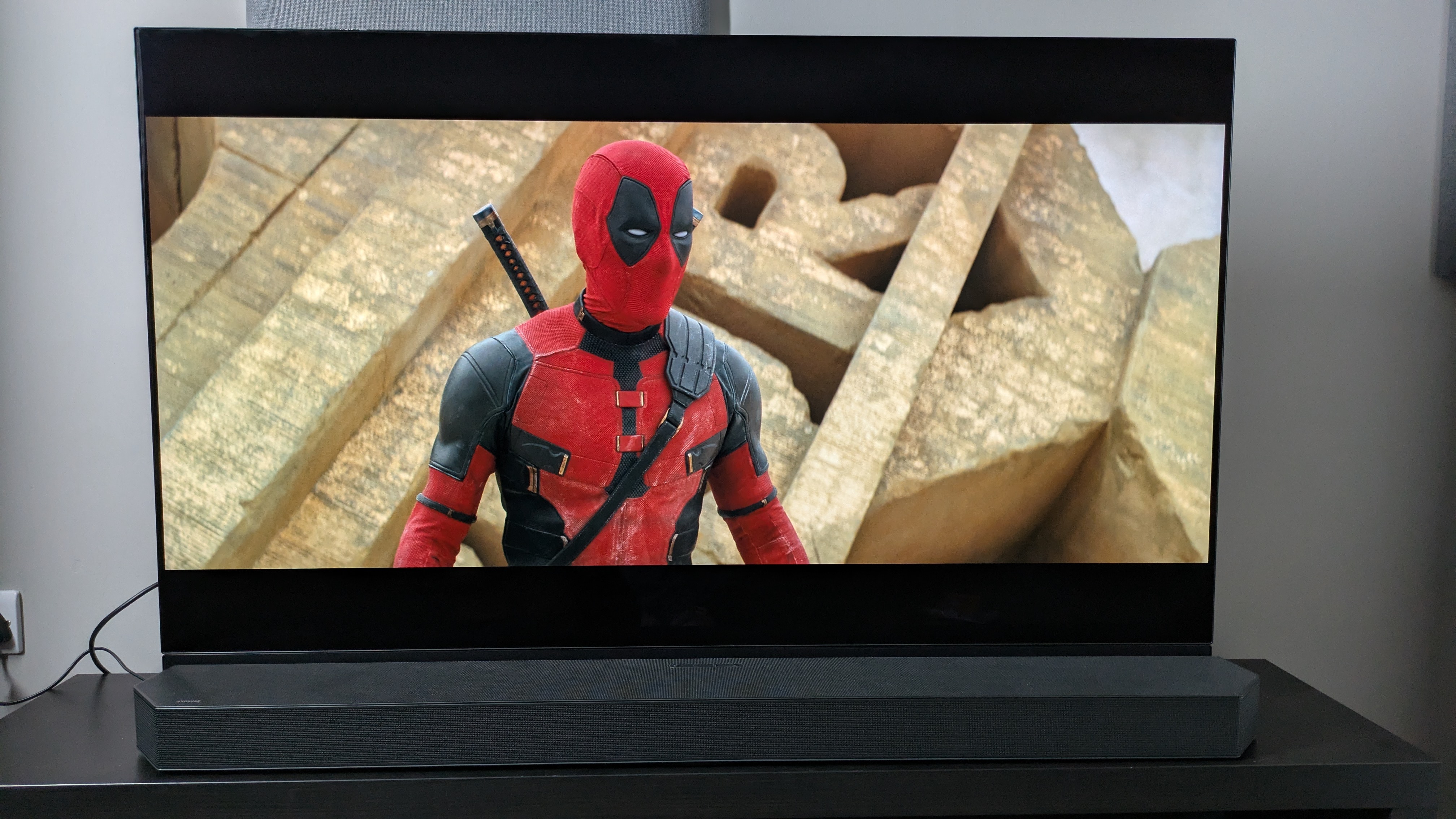 Deadpool & Wolverine image of Deadpool on Panasonic MZ1500 with Samsung HW-Q990C soundbar in front of TV