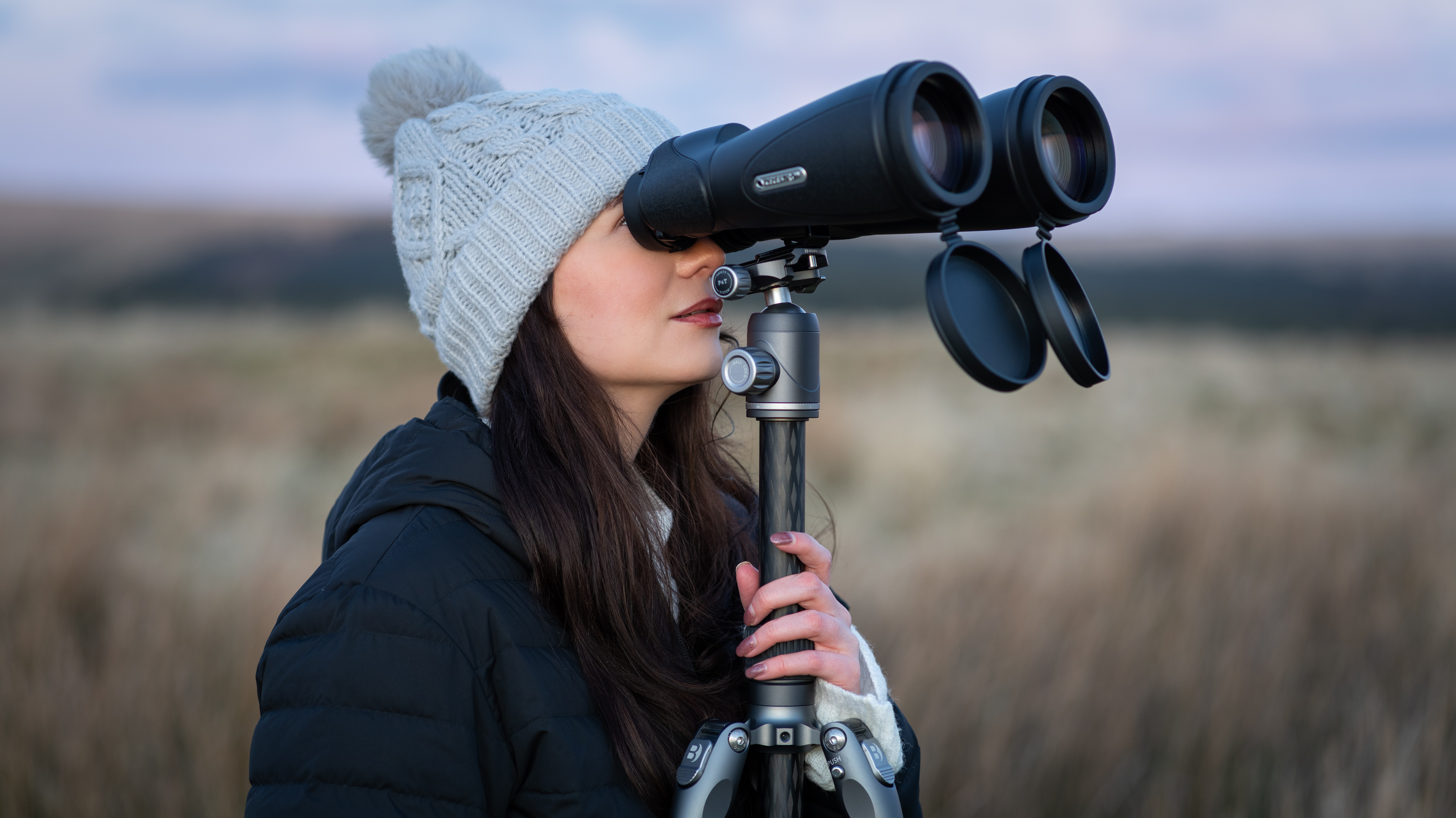 Wanita menggunakan Binoculars Celestron Skymaster Pro ed 15x70 pada tripod