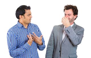 man looking at guy closing, covering nose, something stinks