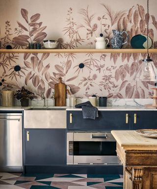 An earthy toned mural demonstrating kitchen wall decor ideas above blue painted cabinetry and a geometric tiled floor.