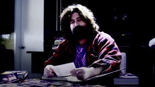 Mick Foley looking at photos in For All Mankind: The Life And Career Of Mick Foley