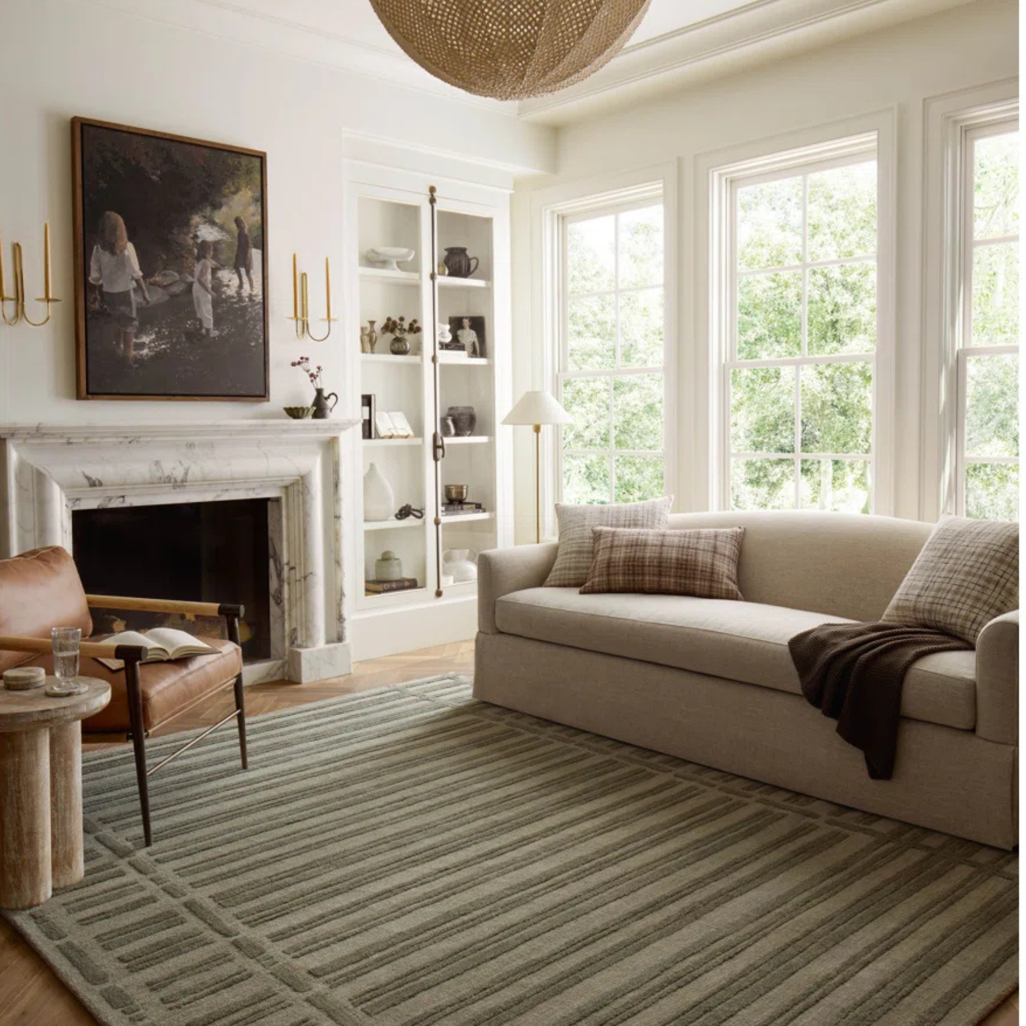 A sage green striped and textured rug in a neutral living room