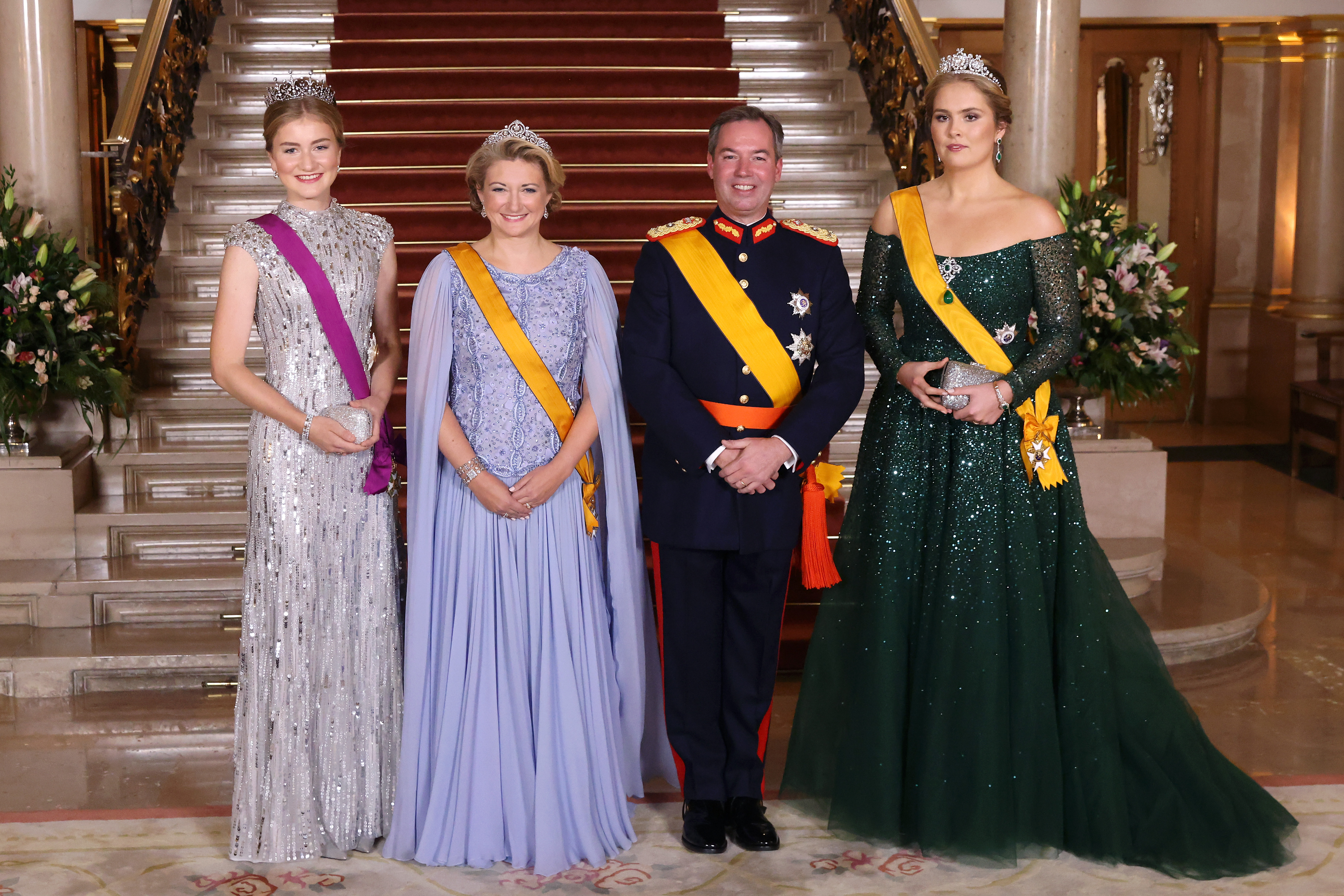 Princess Elisabeth, Grand Duchess Stephanie, Grand Duke Guillaume, Princess Catharina-Amalia wearing evening gowns and military uniform in front of a staircase