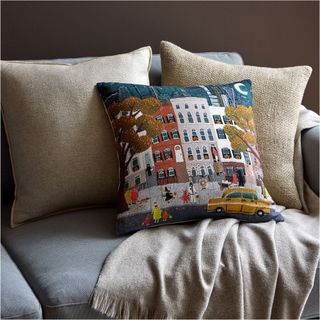 An embroidered pillow from West Elm with a city trick or treating design on the front