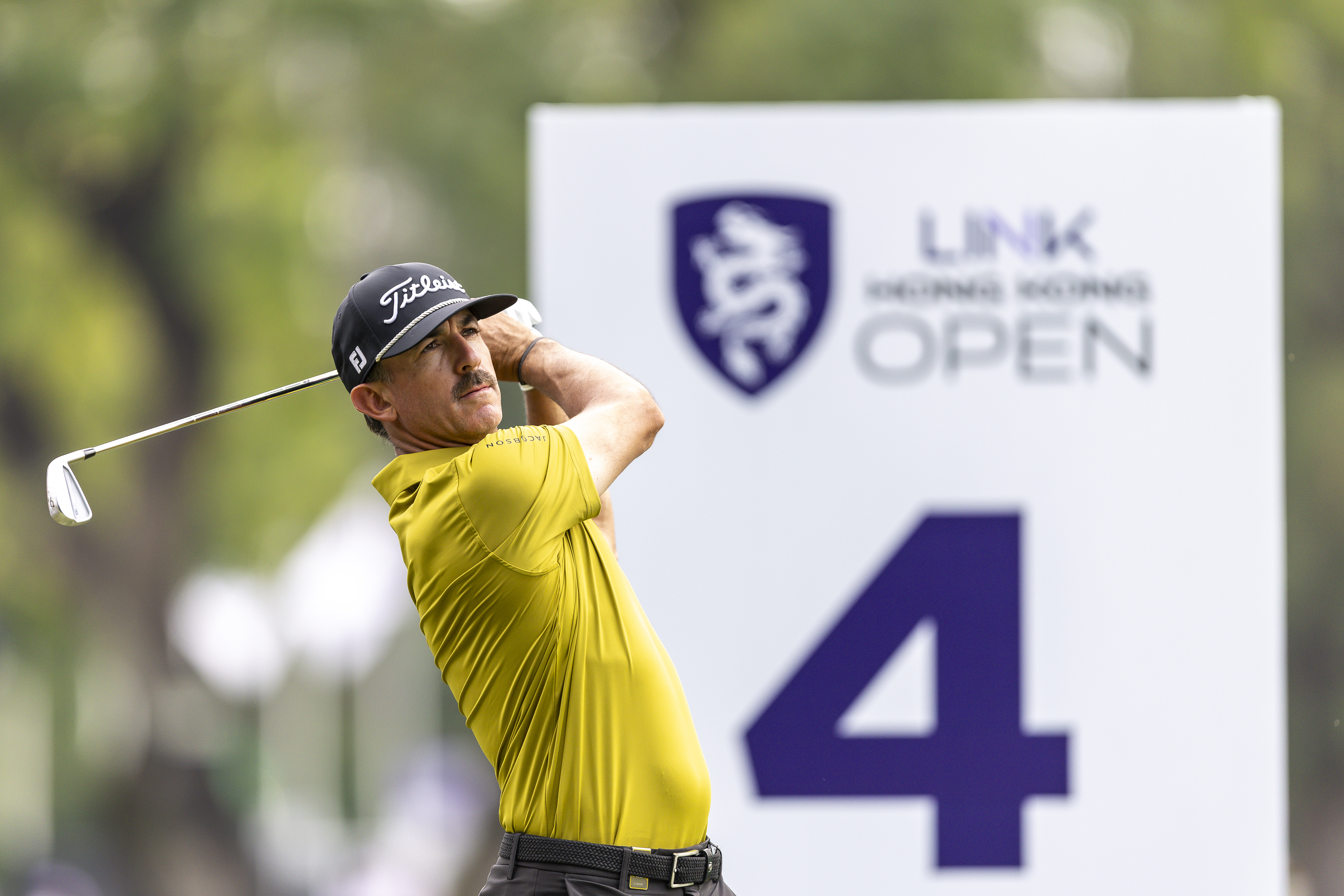 Wade Ormsby holds his finish on an iron shot in front of a 4th tee sign at the Hong Kong Open